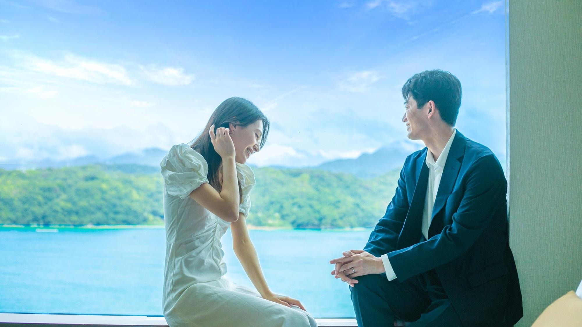 部屋から瀬戸内海を眺めている夫婦